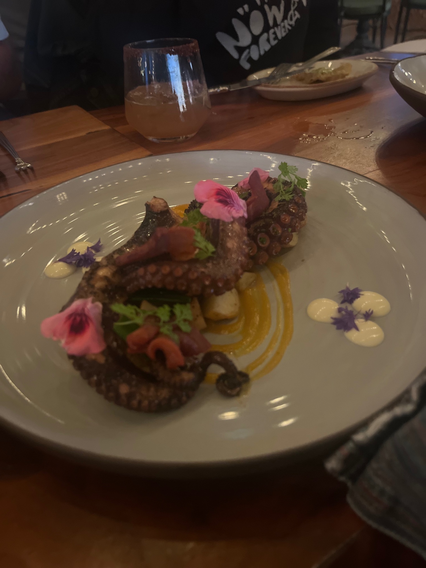 Grilled octopus with edible flowers and squash cream.
