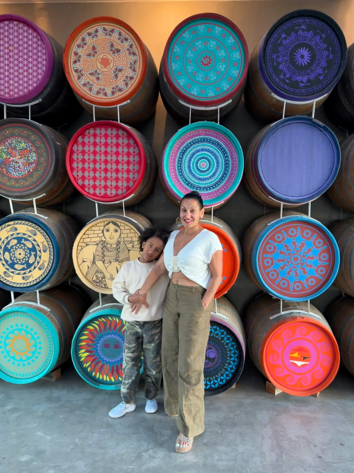 The Jostein family of Antigua Valle in front of hand-painted barrels at a Valle de Guadalupe winery — art, wine, and family tradition.